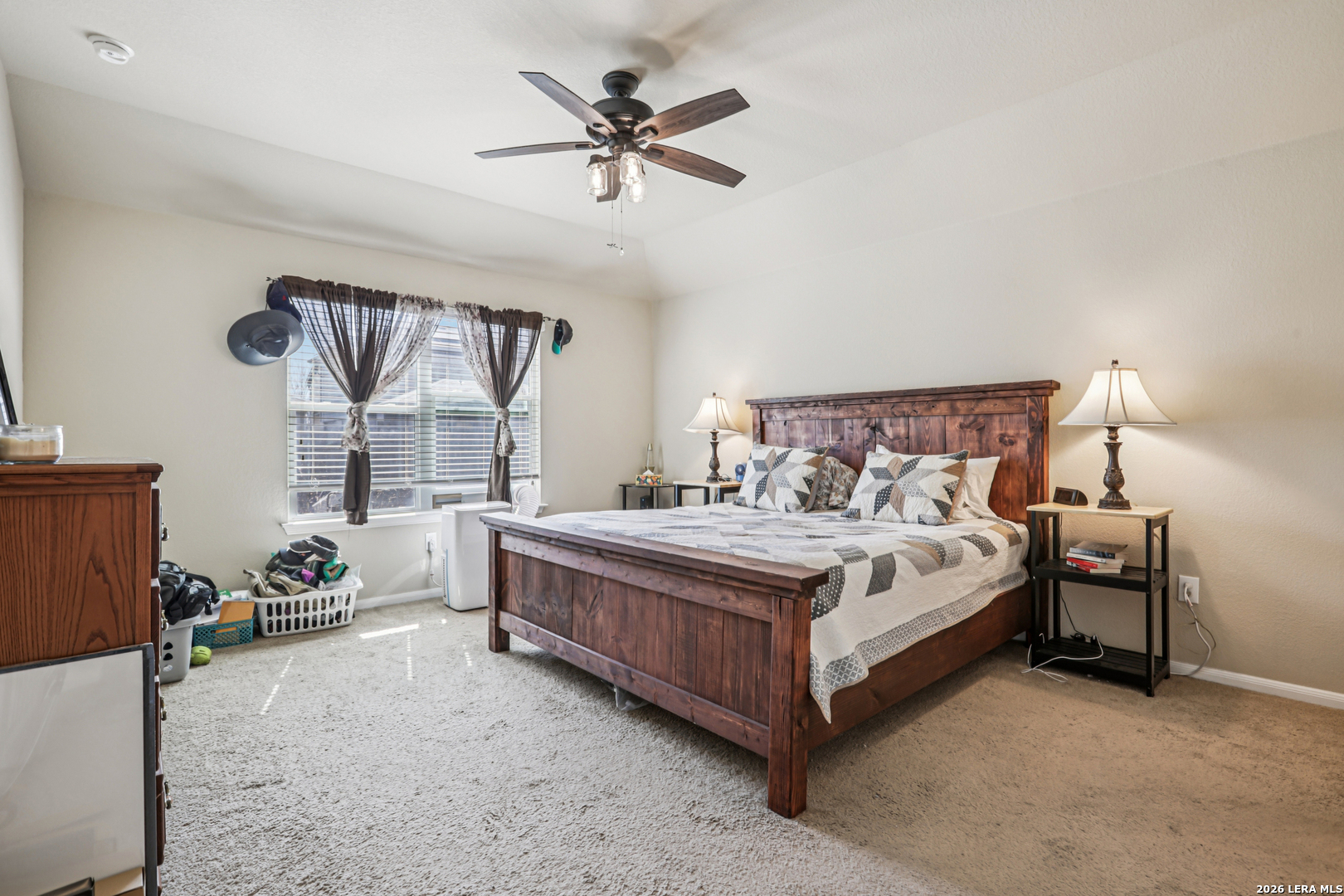 12103 Riprap Drive Manor, TX 78653 - Photo 10 of 13 a bed sitting in a bedroom next to a window with a chandelier