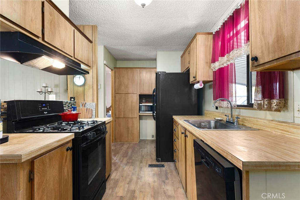 3835 Gardiner Ferry Road, Unit 2 Corning, CA 96021 - Photo 16 of 51 a kitchen with stainless steel appliances granite countertop a sink a refrigerator and a stove