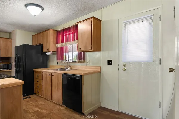 a kitchen with a refrigerator sink and wooden cabinets