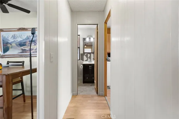 a view of a hallway with wooden floor and dining room