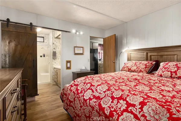 a bedroom with a large bed and wooden floor