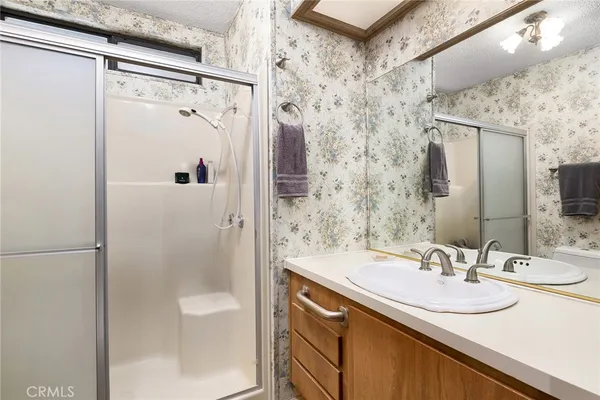 a bathroom with a sink shower and a mirror