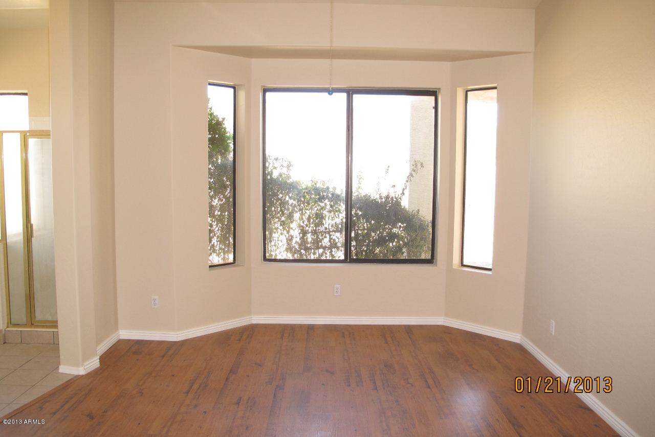 525 South Boyd Road Apache Junction, AZ 85119 - Photo 17 of 39 an empty room with wooden floor and windows
