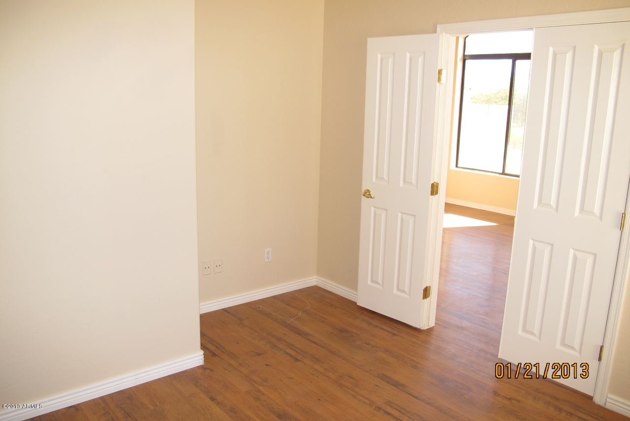 525 South Boyd Road Apache Junction, AZ 85119 - Photo 8 of 39 an empty room with wooden floor and windows