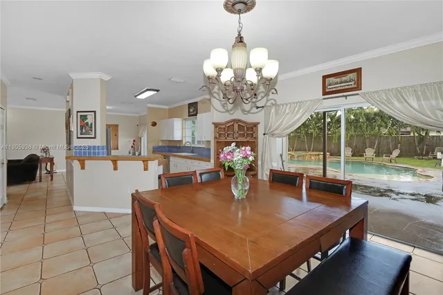 a dining room with wooden floor a chandelier a wooden table and chairs