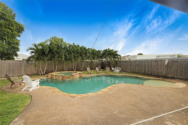 a view of a backyard with couches plants and large tree