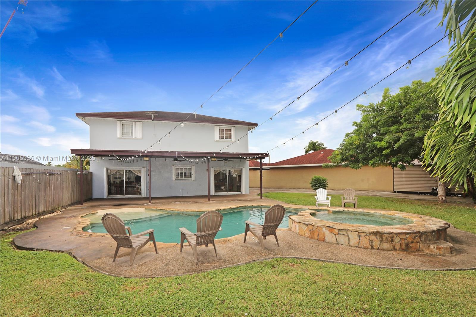 14723 Southwest 142nd Street Miami, FL 33196 - Photo 7 of 25 a view of a house with a big yard dining table and chairs under an umbrella