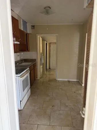 a kitchen with granite countertop a stove top oven and cabinets