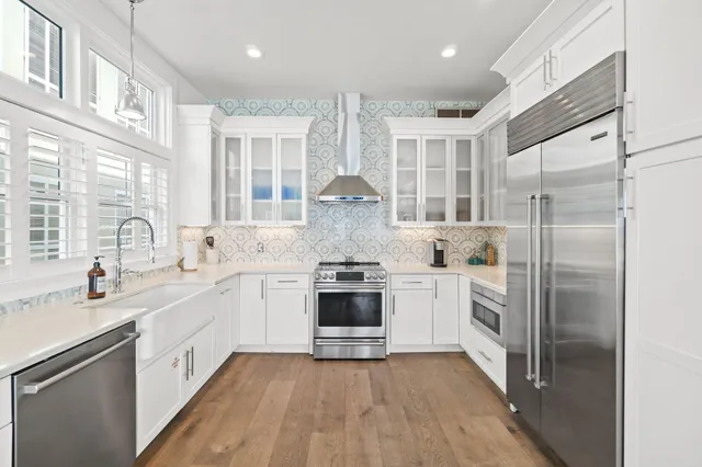 a large kitchen with stainless steel appliances granite countertop a stove and a sink