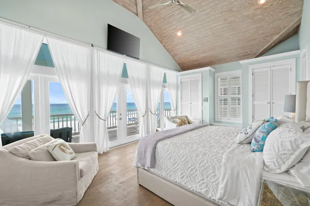 a spacious bedroom with a bed and glass window