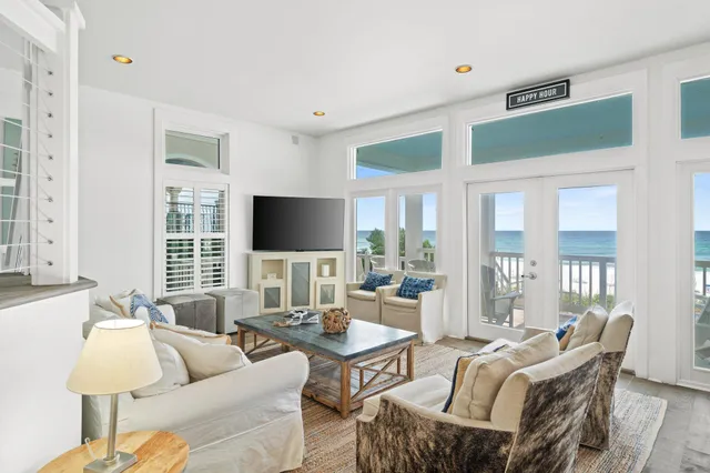 a living room with furniture a flat screen tv and a large window