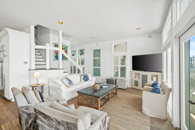 a living room with furniture a flat screen tv and a large window