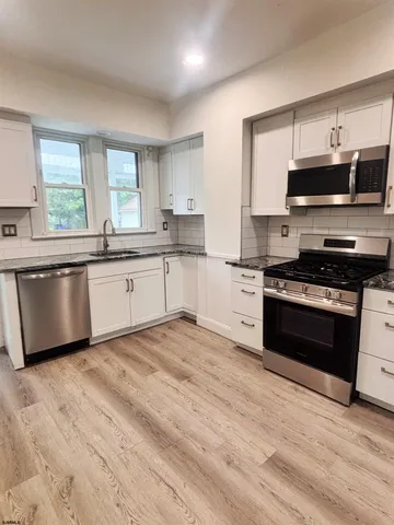 a kitchen with stainless steel appliances granite countertop a stove and a sink