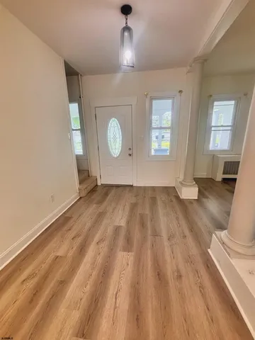 a view of empty room with wooden floor