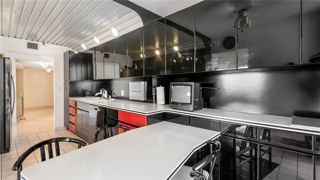 8877 Collins Avenue, Unit 1107 Surfside, FL 33154 - Photo 13 of 42 a kitchen that has a lot of cabinets in it