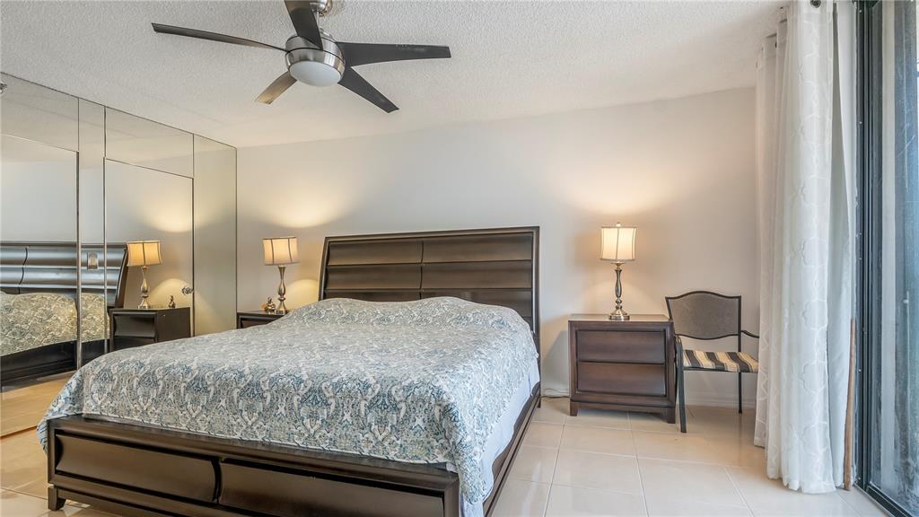 8877 Collins Avenue, Unit 1107 Surfside, FL 33154 - Photo 16 of 42 a bedroom with a bed piano and wooden floor