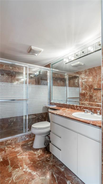 8877 Collins Avenue, Unit 1107 Surfside, FL 33154 - Photo 19 of 42 a bathroom with a toilet sink and mirror