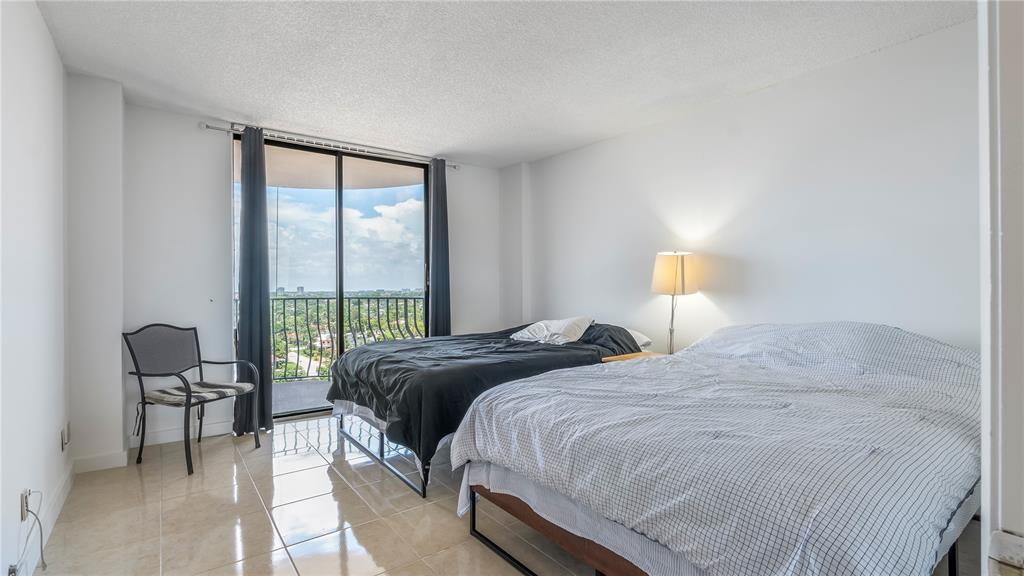 8877 Collins Avenue, Unit 1107 Surfside, FL 33154 - Photo 25 of 42 a bedroom with a bed and a large window