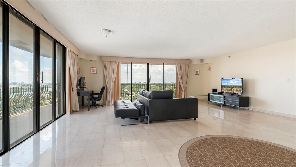 8877 Collins Avenue, Unit 1107 Surfside, FL 33154 - Photo 33 of 42 a living room with furniture and a floor to ceiling window