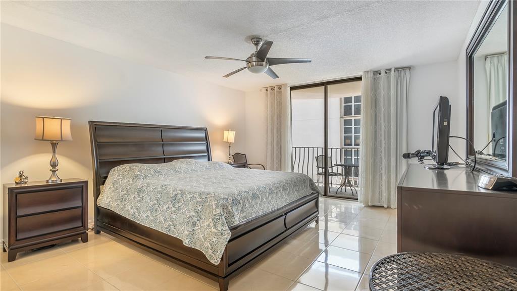 8877 Collins Avenue, Unit 1107 Surfside, FL 33154 - Photo 34 of 42 a bedroom with a bed and a walk in closet