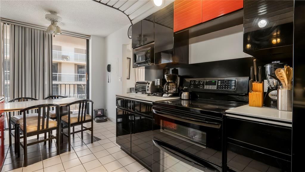 8877 Collins Avenue, Unit 1107 Surfside, FL 33154 - Photo 7 of 42 a kitchen with stainless steel appliances granite countertop a stove a sink and a refrigerator
