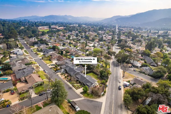 an aerial view of residential house with an outdoor space and seating