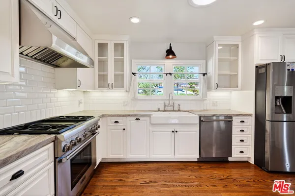 a kitchen with stainless steel appliances granite countertop a stove a sink and a refrigerator
