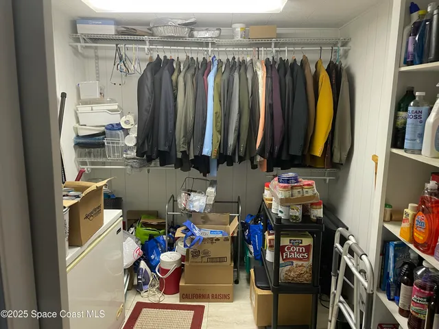 a view of walk in closet with clothes and shoes