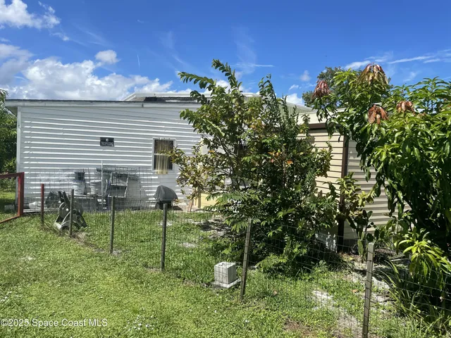 a backyard of a house with table and chairs