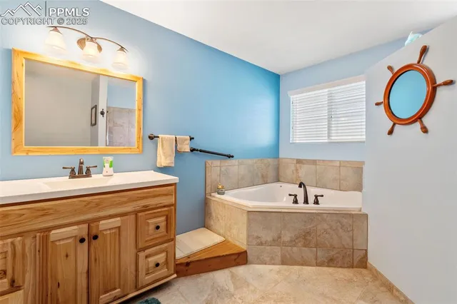 a spacious bathroom with a tub sink and mirror
