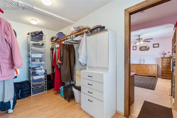 a view of walk in closet with clothes and shoes