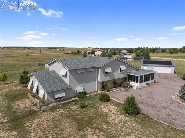 an aerial view of a house with big yard and large tree