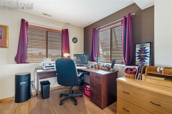 a view of a workspace with furniture and a window