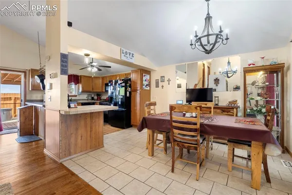 a view of a dining room with furniture a chandelier and kitchen view