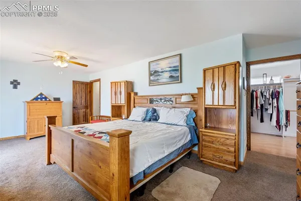 a bedroom with a bed and a refrigerator