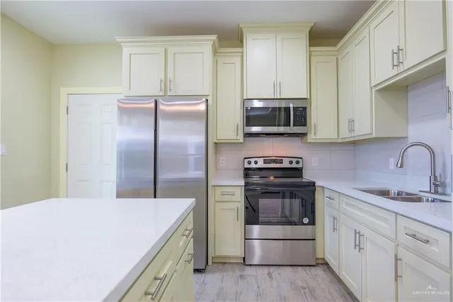 a kitchen with kitchen island a sink stainless steel appliances and cabinets