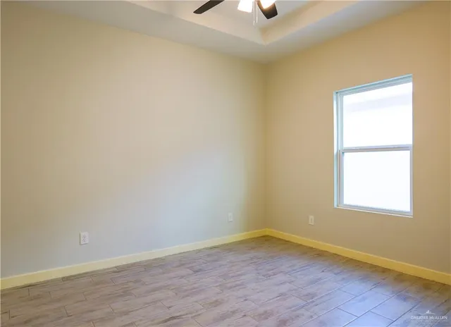 an empty room with a window and wooden floor