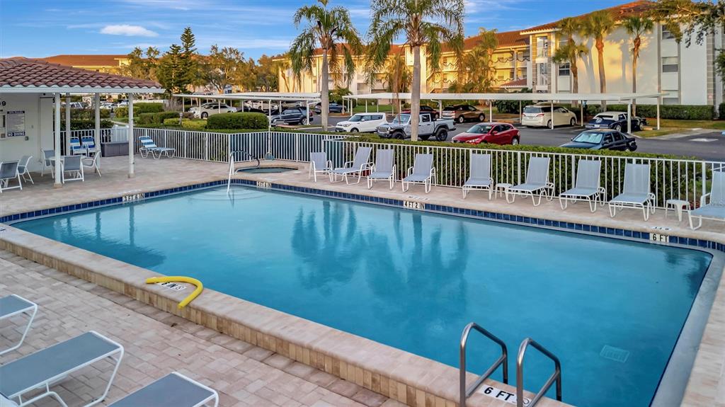 6507 Stone River Road, Unit 105 Bradenton, FL 34203 - Photo 13 of 62 a view of a swimming pool with a chair and tables in the patio