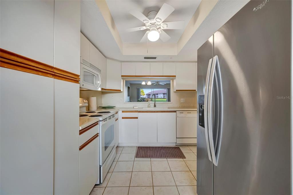 6507 Stone River Road, Unit 105 Bradenton, FL 34203 - Photo 33 of 62 a kitchen with stainless steel appliances granite countertop a refrigerator and a stove top oven