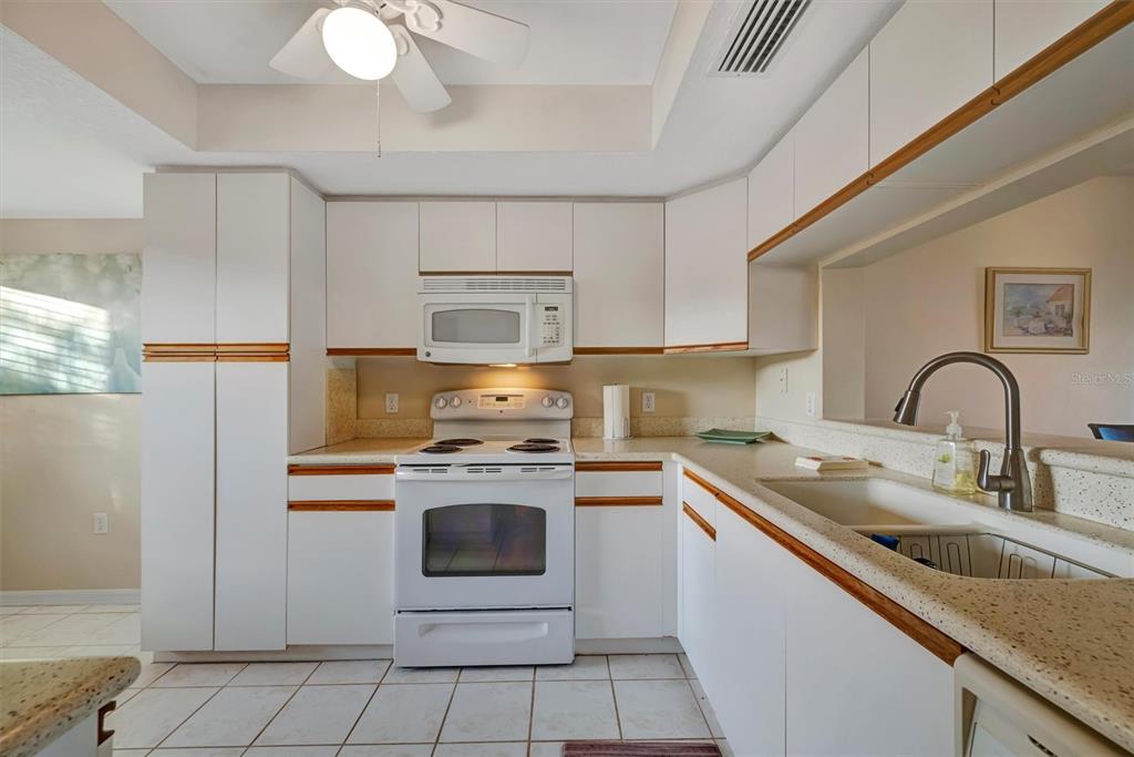 6507 Stone River Road, Unit 105 Bradenton, FL 34203 - Photo 34 of 62 a kitchen with kitchen island a white stove top oven and sink
