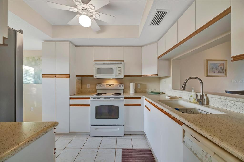 6507 Stone River Road, Unit 105 Bradenton, FL 34203 - Photo 35 of 62 a kitchen with stainless steel appliances granite countertop a sink a stove and refrigerator