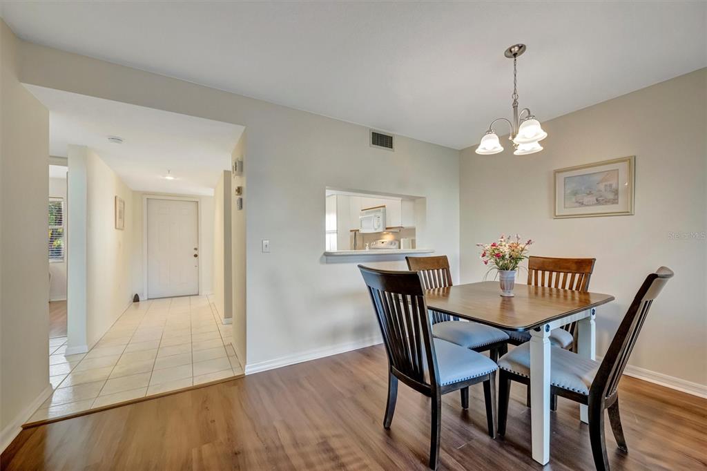 6507 Stone River Road, Unit 105 Bradenton, FL 34203 - Photo 39 of 62 a view of a dining room with furniture wooden floor and a chandelier