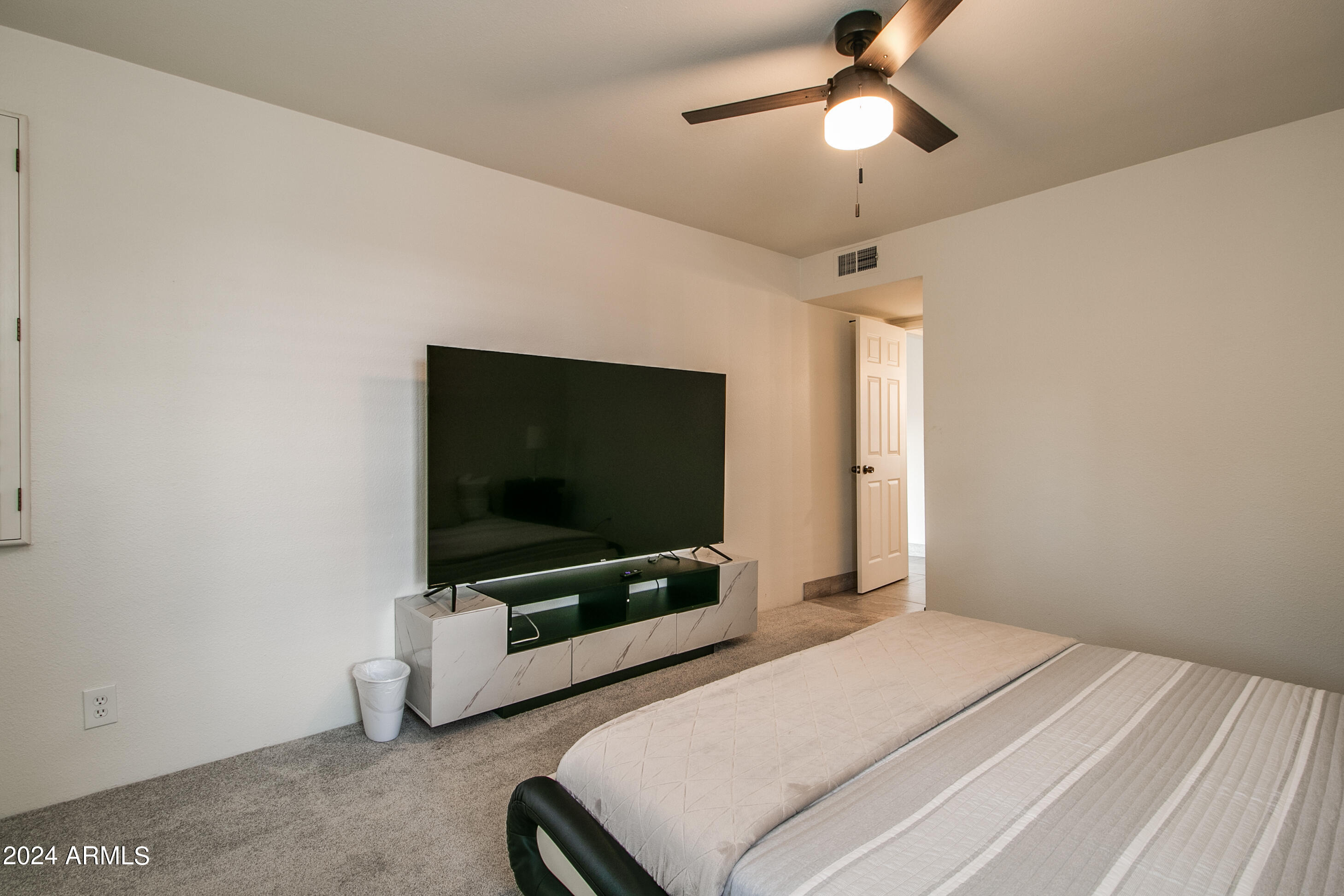 7625 East Camelback Road, Unit 252B Scottsdale, AZ 85251 - Photo 25 of 26 a bedroom with a bed and a flat screen tv