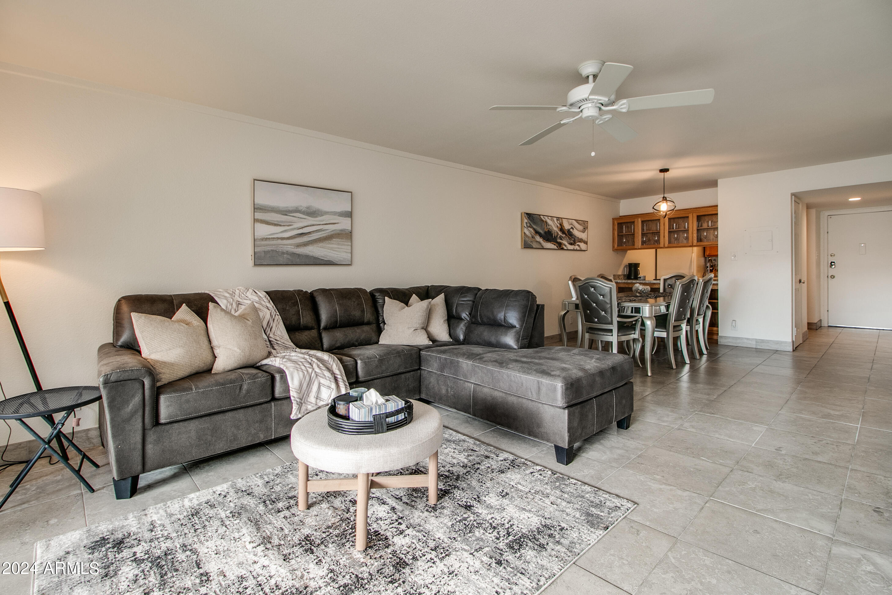 7625 East Camelback Road, Unit 252B Scottsdale, AZ 85251 - Photo 3 of 26 a living room with furniture and a dining table with kitchen view
