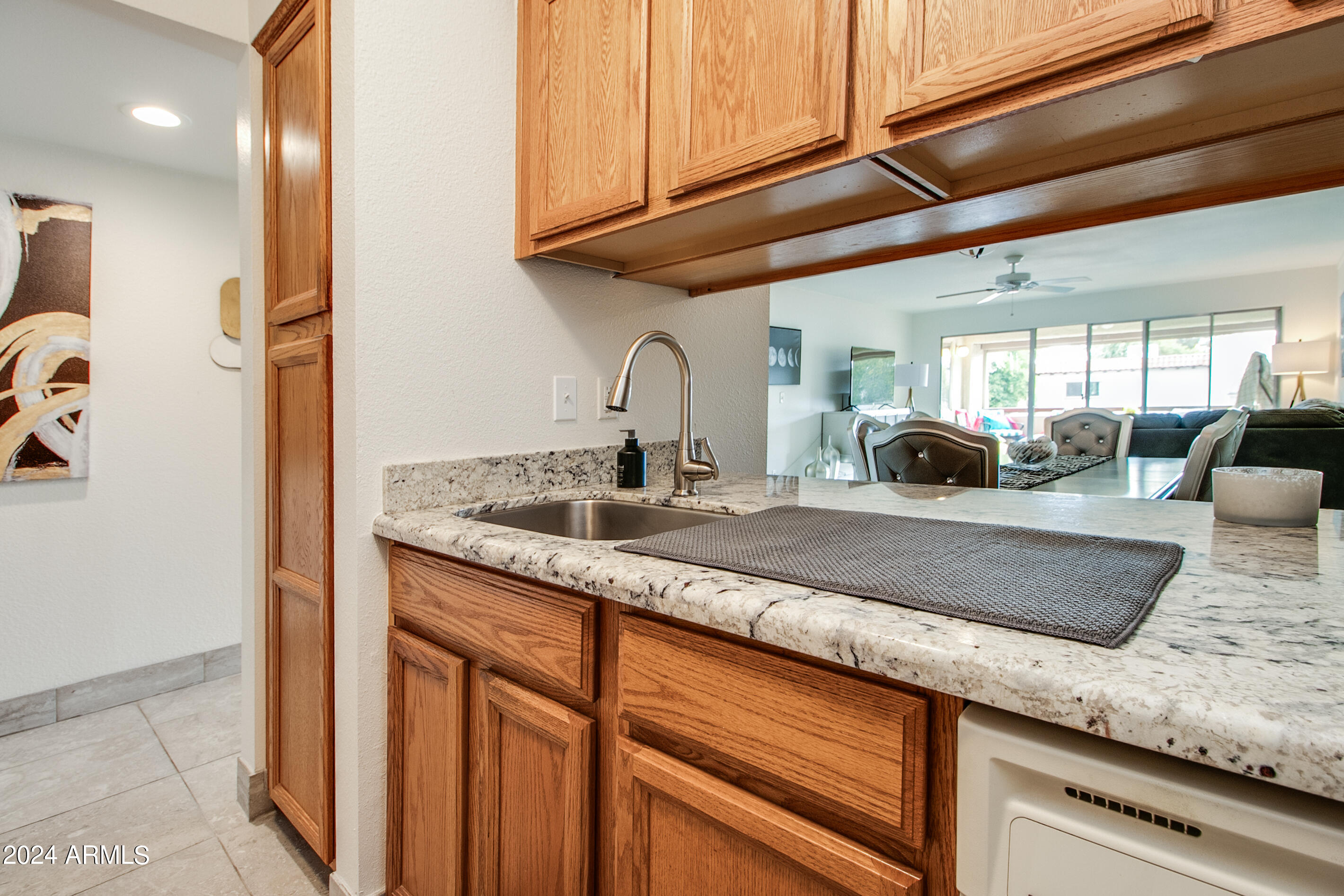7625 East Camelback Road, Unit 252B Scottsdale, AZ 85251 - Photo 10 of 26 a kitchen with stainless steel appliances granite countertop a sink a counter space and cabinets
