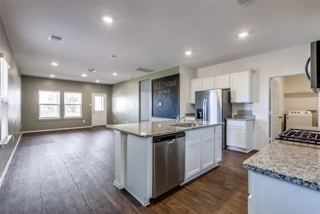 a kitchen with stainless steel appliances granite countertop a sink stove and refrigerator