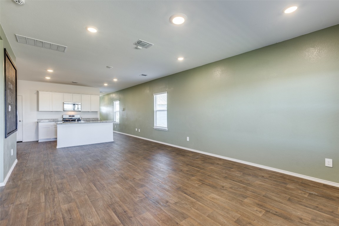 543 Sandringham Loop Kyle, TX 78640 - Photo 20 of 20 a view of an empty room with wooden floor and a kitchen