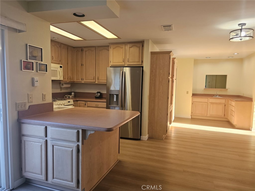 25132 Highspring Avenue Newhall, CA 91321 - Photo 14 of 46 a kitchen with stainless steel appliances granite countertop a sink refrigerator and cabinets