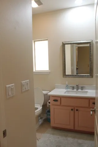 a bathroom with a toilet sink and mirror