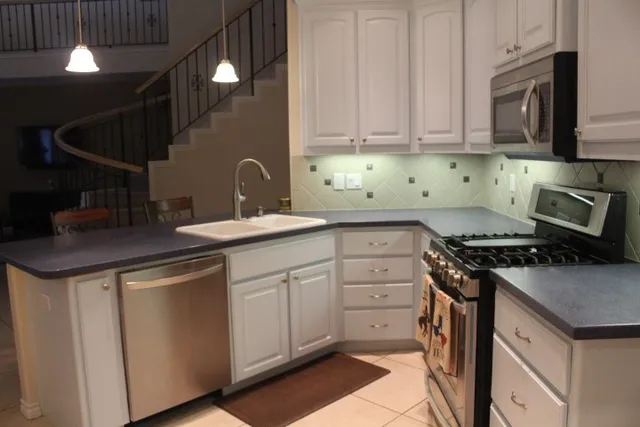 a kitchen with a sink a stove and cabinets